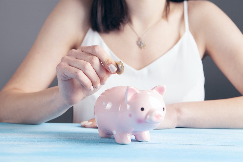 Woman adding money to a piggy bank